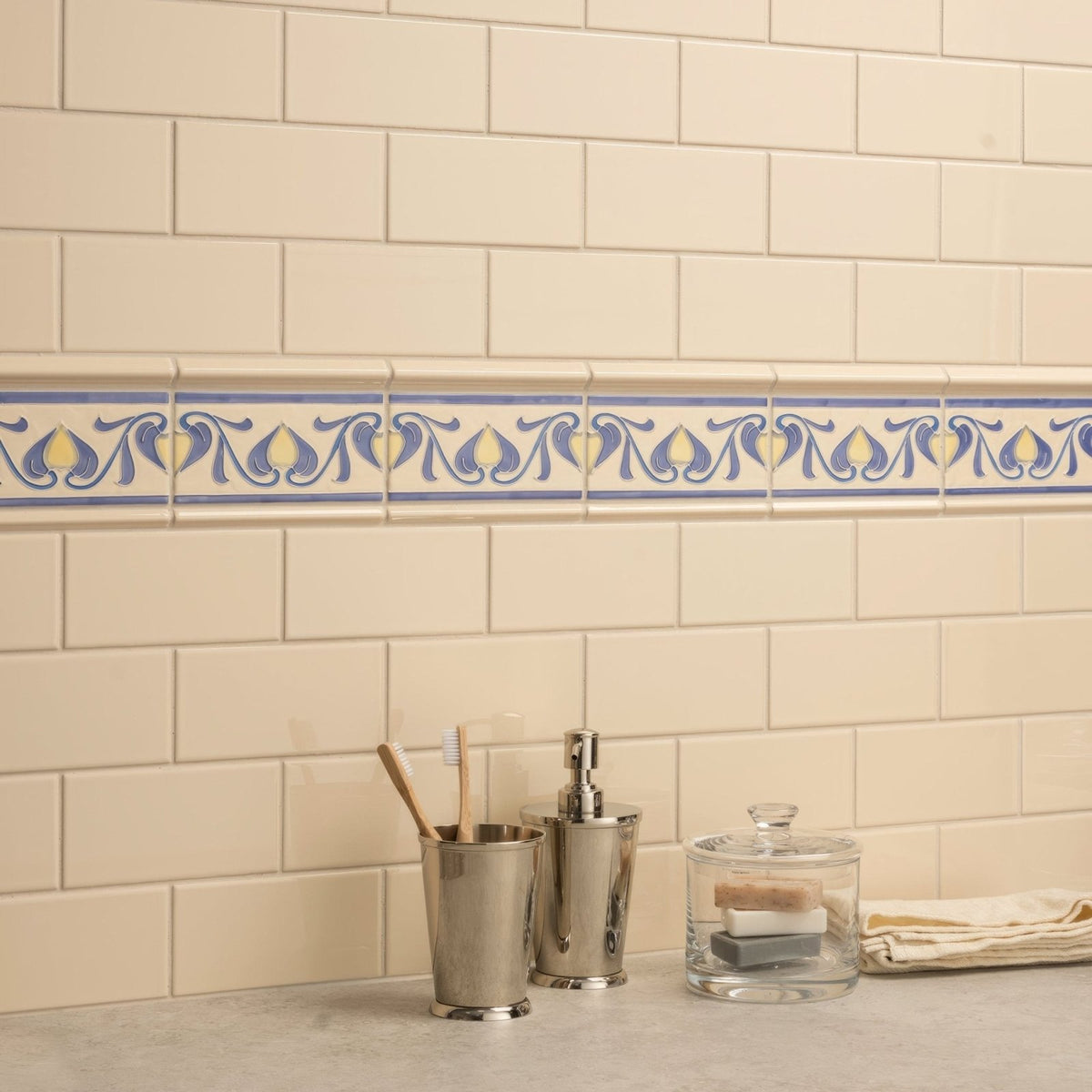 Cream-colored subway tile wall with decorative blue and yellow patterned border tile in county white albert moulding