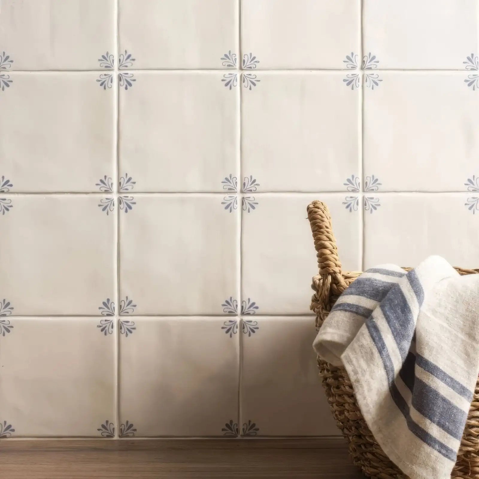 Cream-colored ceramic tiles with subtle gray floral motifs.