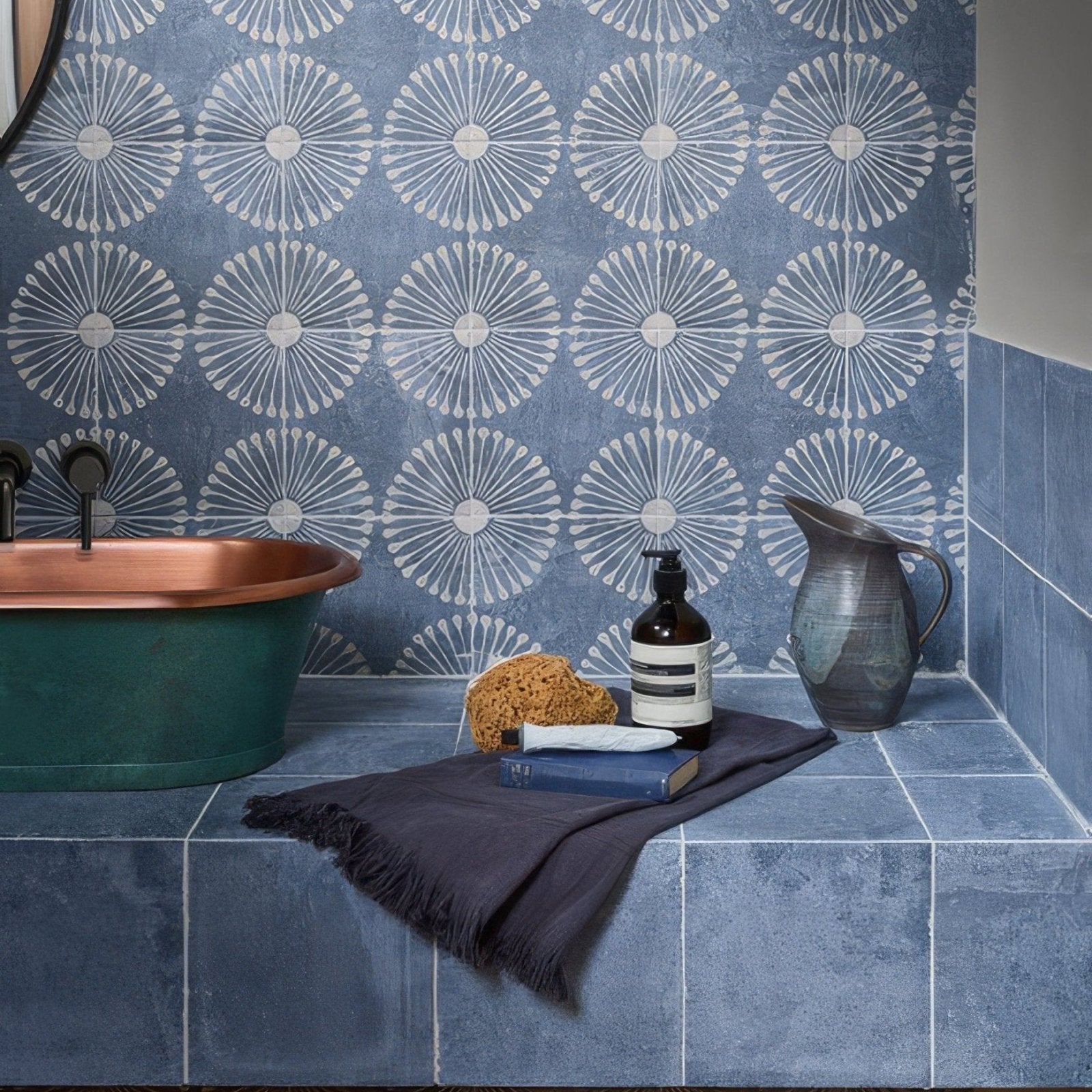 Dark blue cuba porcelain indigo field tile wall with textured surface and white sunburst pattern design