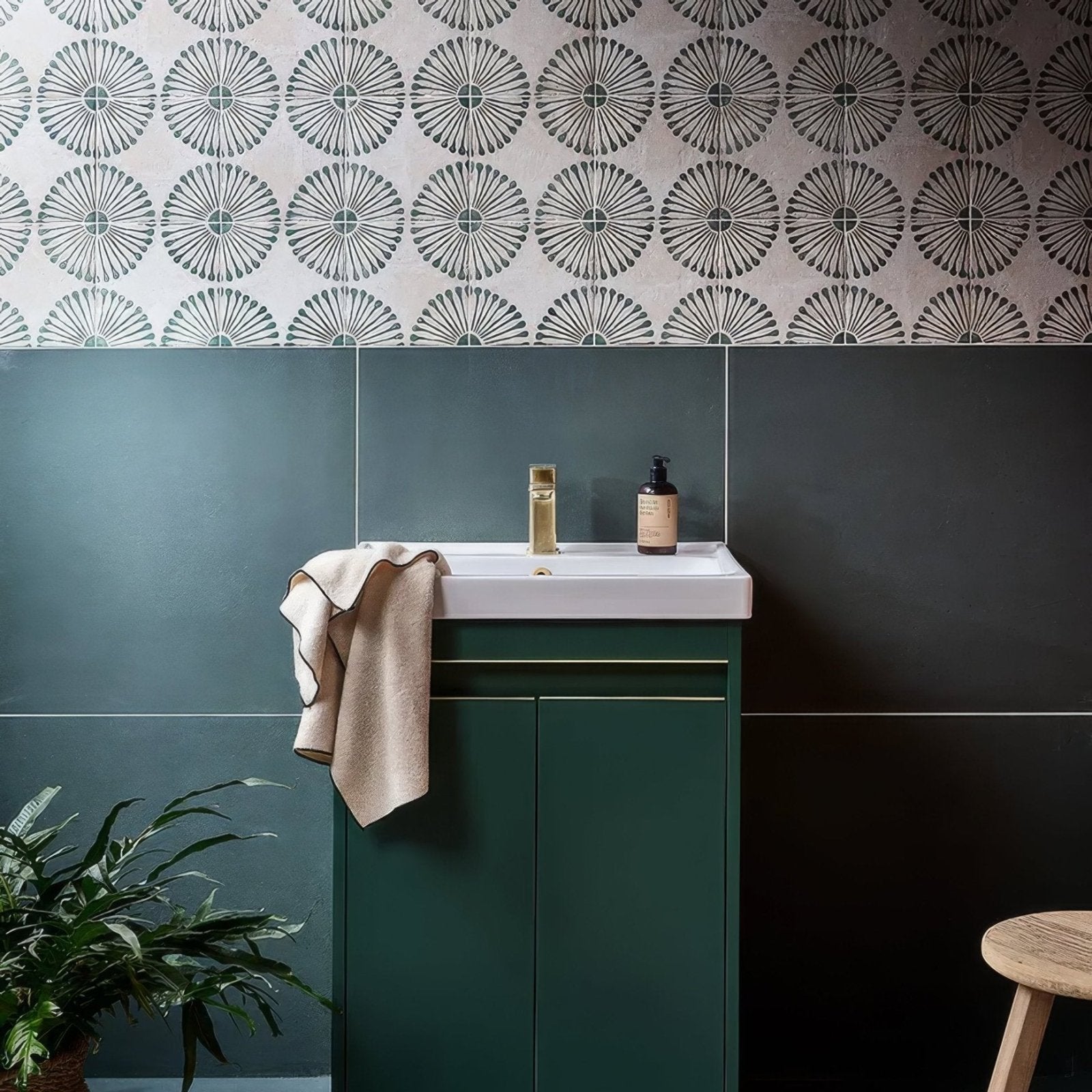 White ceramic sink with gold faucet and dark green porcelain cuba porcelain infantas green cabinet below