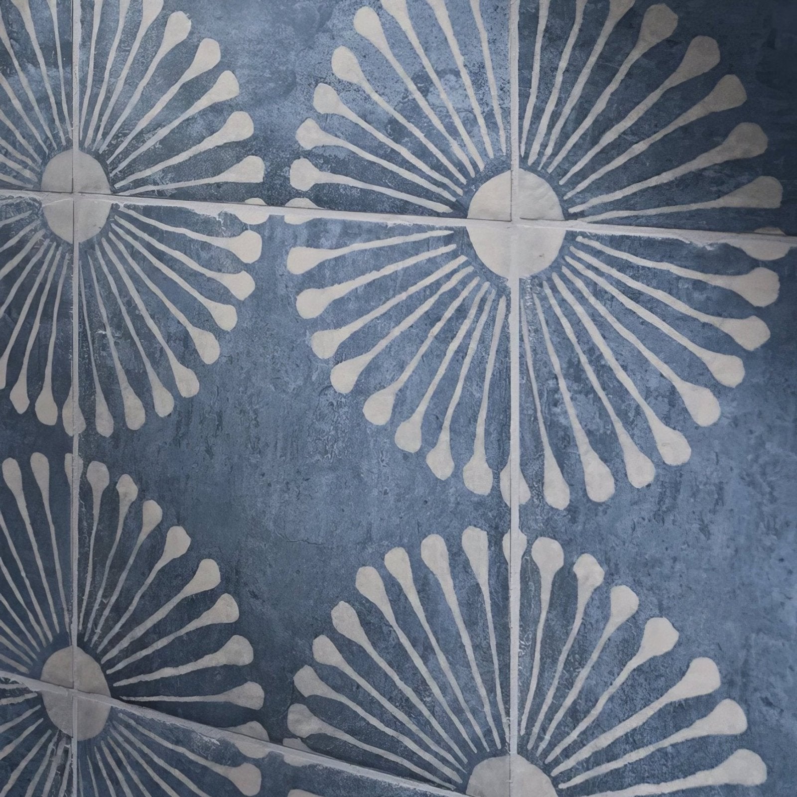 Blue and white sunburst-patterned ceramic floor tiles in cuba porcelain vedado indigo design