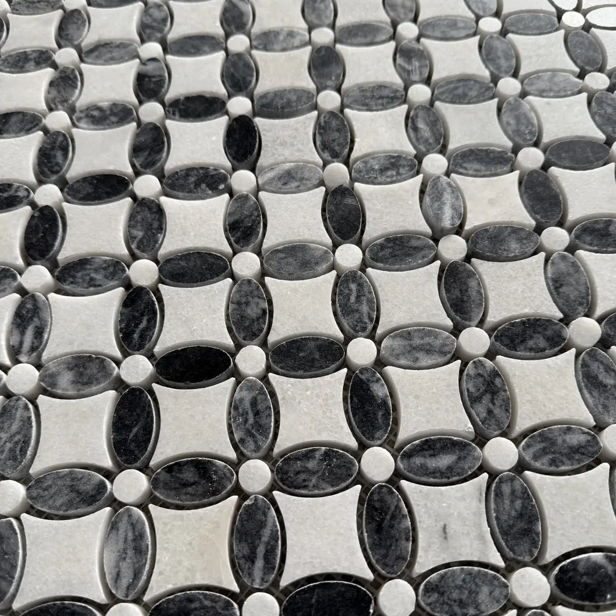 Black and white marble flower mosaic used on a bathroom wall in a room setting
