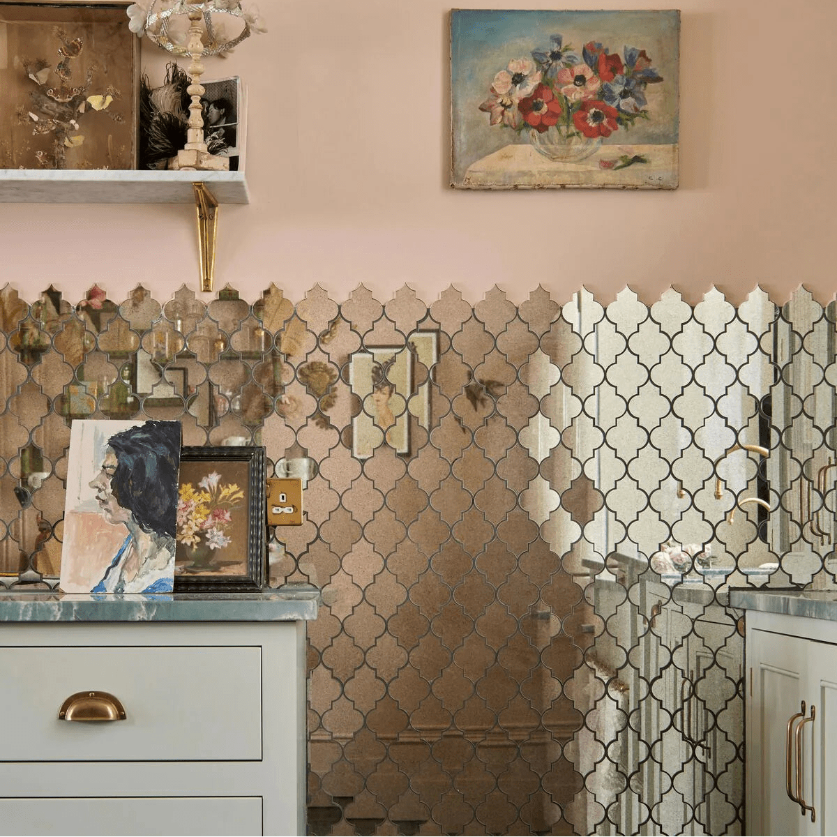 The wall features a deco glass bell silver mosaic with reflective gold and silver quatrefoil mirror tiles