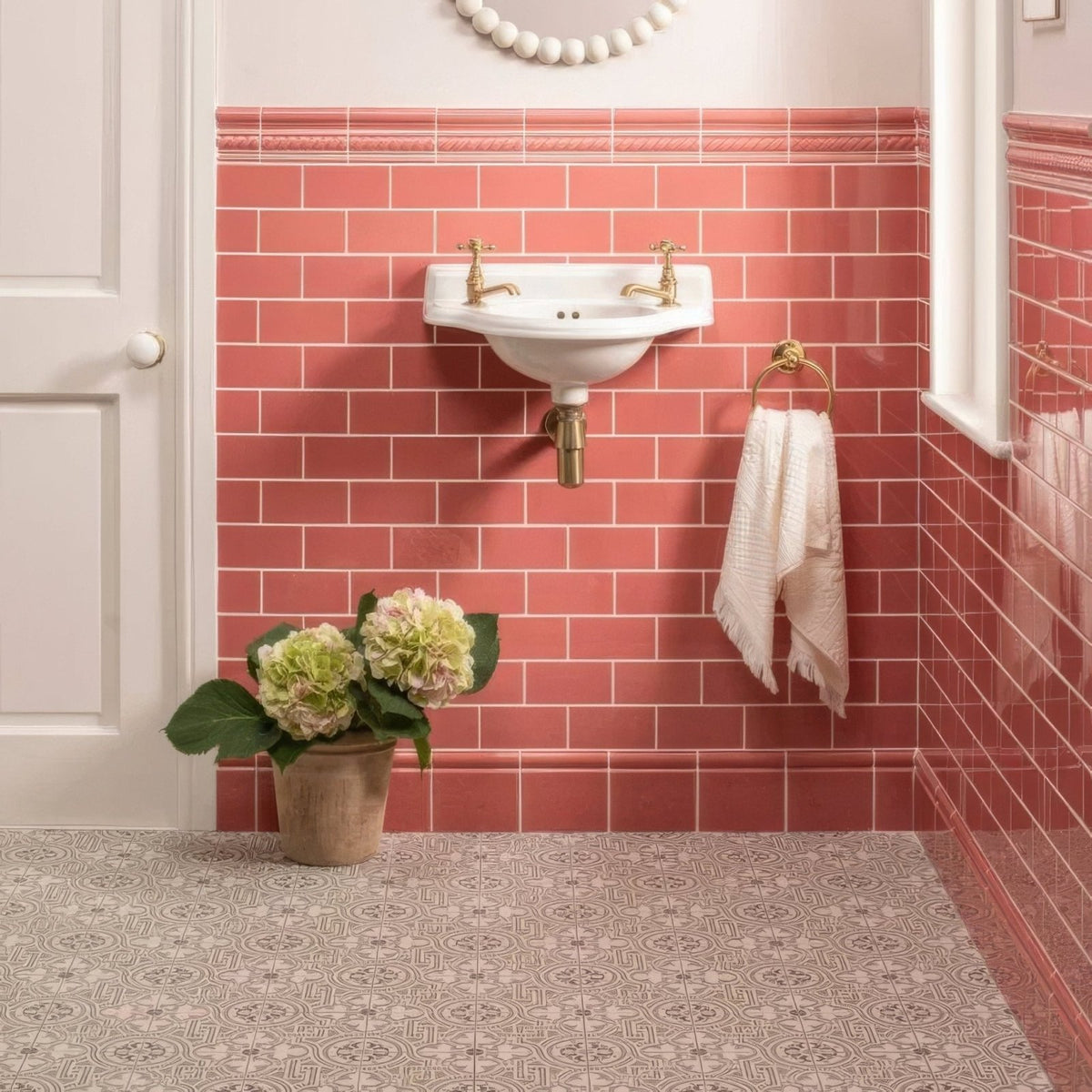 White ceramic wall-mounted duchy pink half tile sink with gold-finished faucets and plumbing features