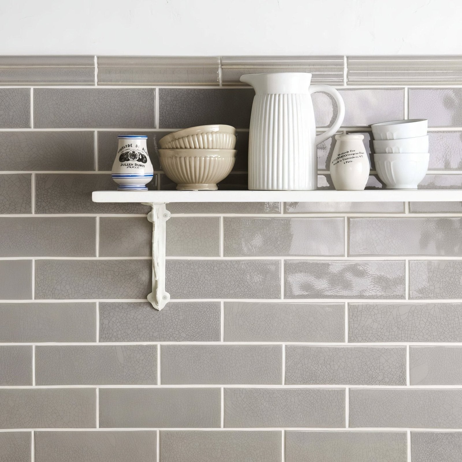 White ceramic pitcher with vertical ridges and curved handle featured in crackle glazed brick tile dunwich design