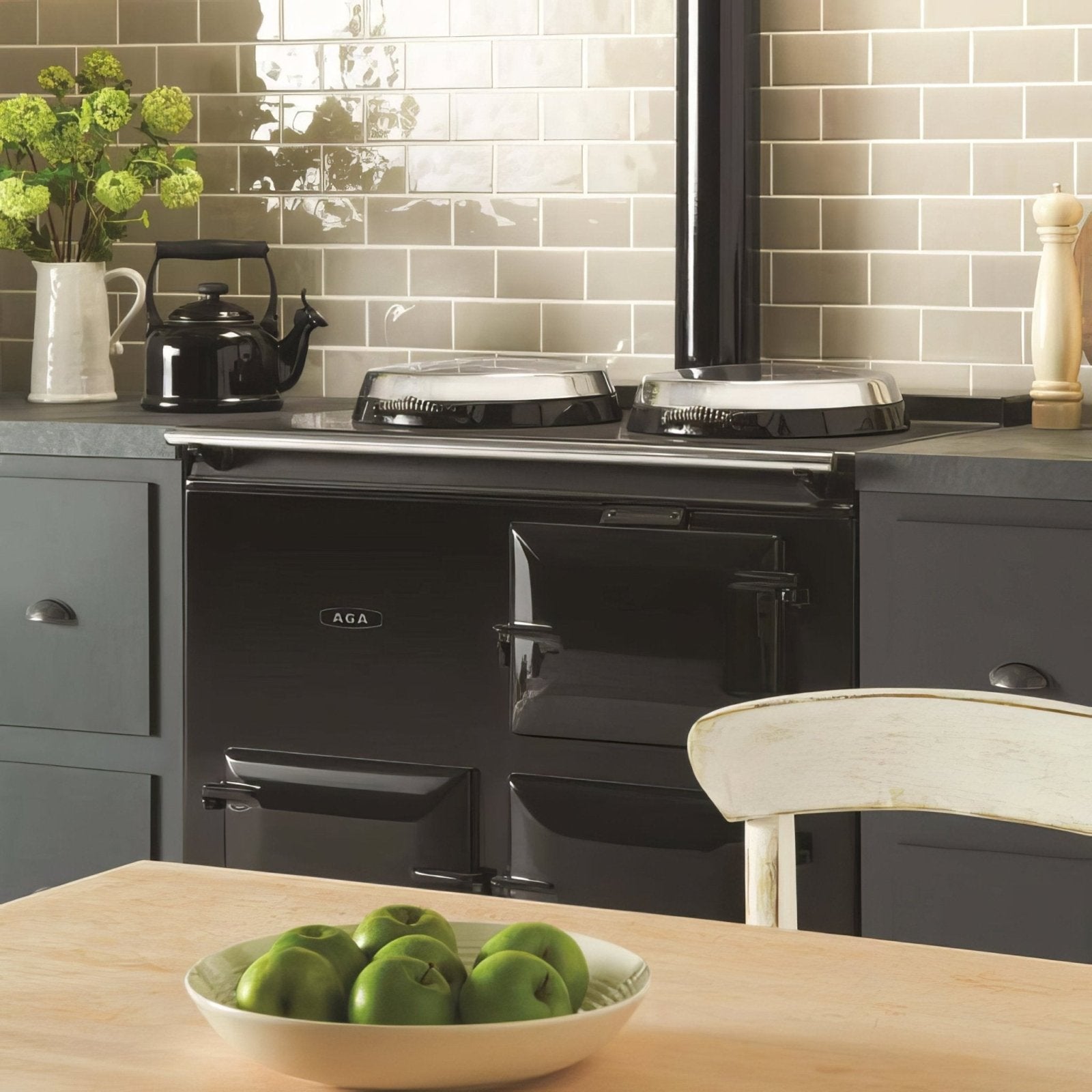 Black aga range cooker with glossy finish and chrome accents shown with dunwich half tile background