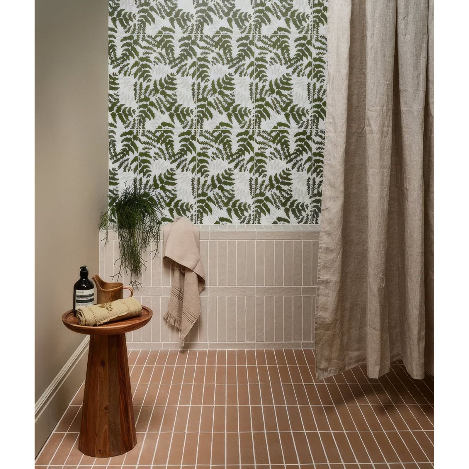 The bathroom features earthenware porcelain plaster tiles with green fern patterns above beige subway tiles