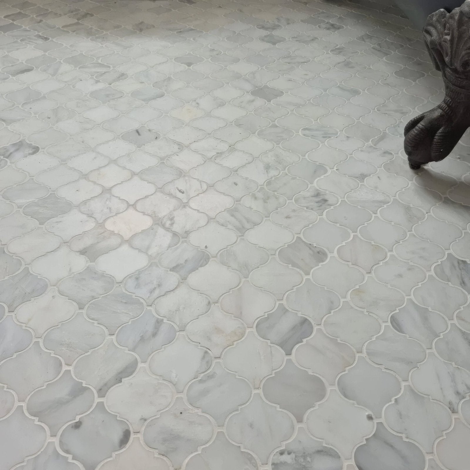 White marble mosaic tiles in an east hampton arabesque pattern with quatrefoil design and subtle gray veining