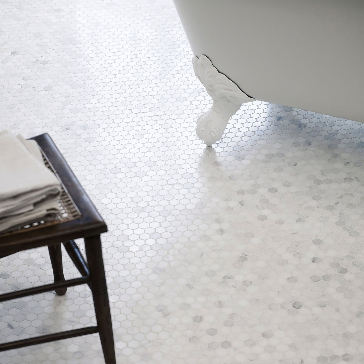 White hexagonal mosaic tile floor with subtle marble veining east hampton hexagon marble mosaic