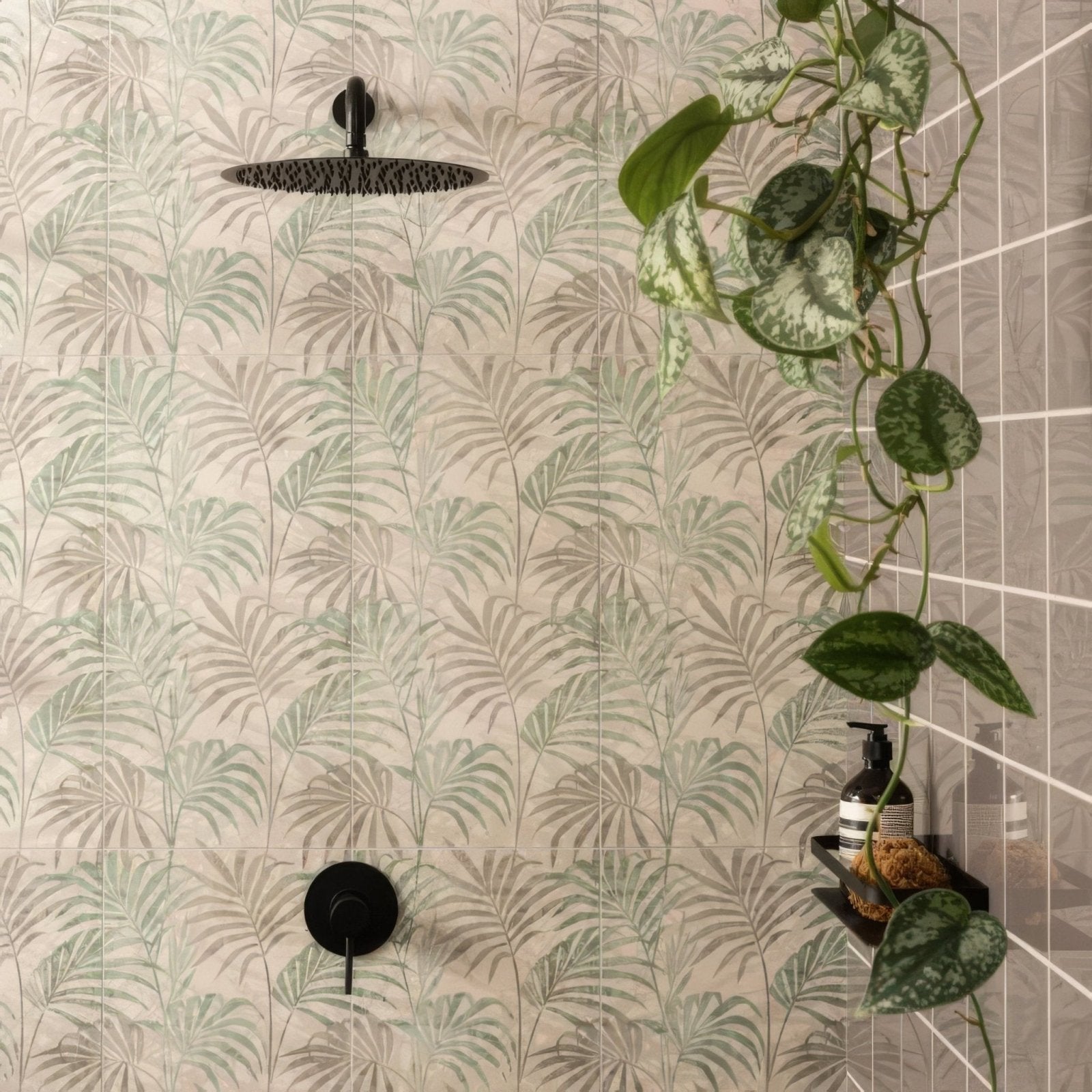 Black matte-finish showerhead with circular textured surface mounted on eden hothouse tropical leaf tiled wall