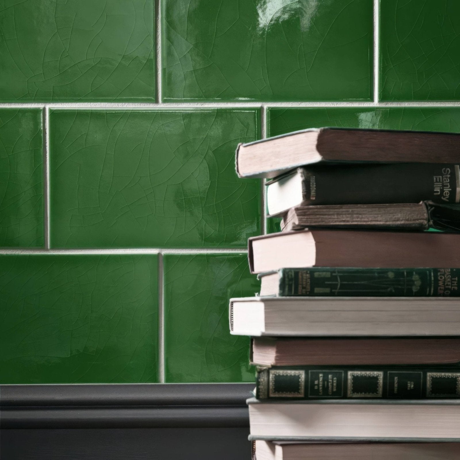 Stack of edwardian caledonian base books with varied dark green brown black and cream spines and covers