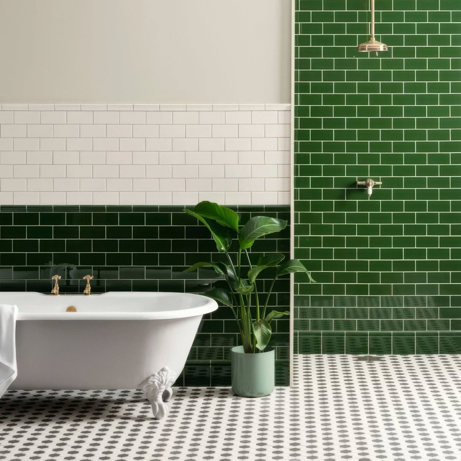A white clawfoot bathtub with gold fixtures against a wall of edwardian green glossy subway tiles