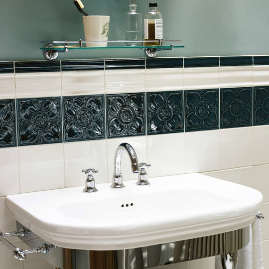 Empress Beatrice Tourmaline white ceramic pedestal sink with polished chrome faucet and handles against dark green tiles
