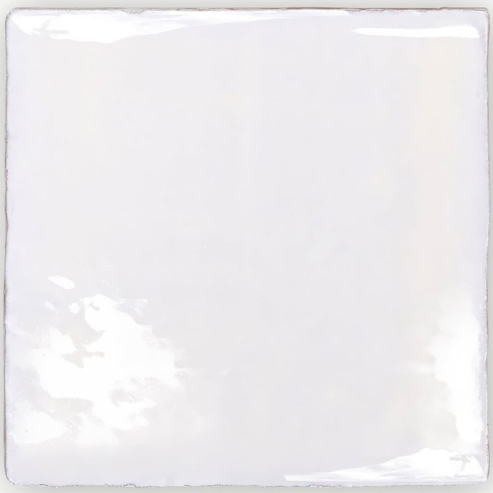 A square glossy white ceramic tile with slightly uneven edges and subtle reflections from traditional english delft base