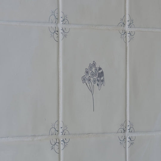 White ceramic tile english delft charcoal bee with gray floral and insect illustration and decorative corner motifs