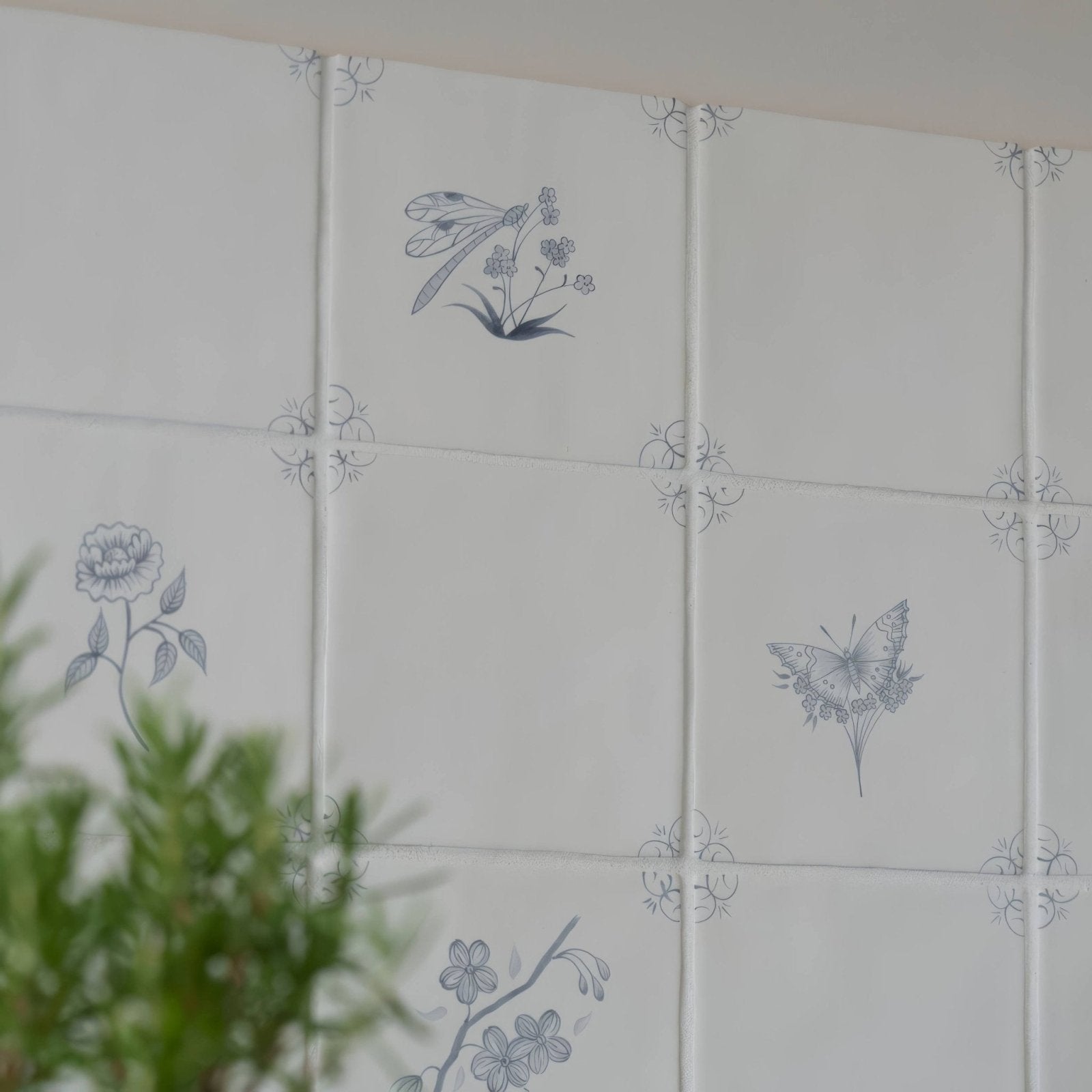 White ceramic tiles with delicate gray botanical illustrations of butterflies dragonflies and flowers english delft charcoal blossom