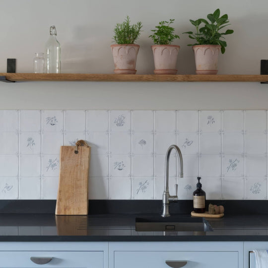A sleek modern stainless steel kitchen faucet with curved spout and single handle in english delft charcoal snowdrop