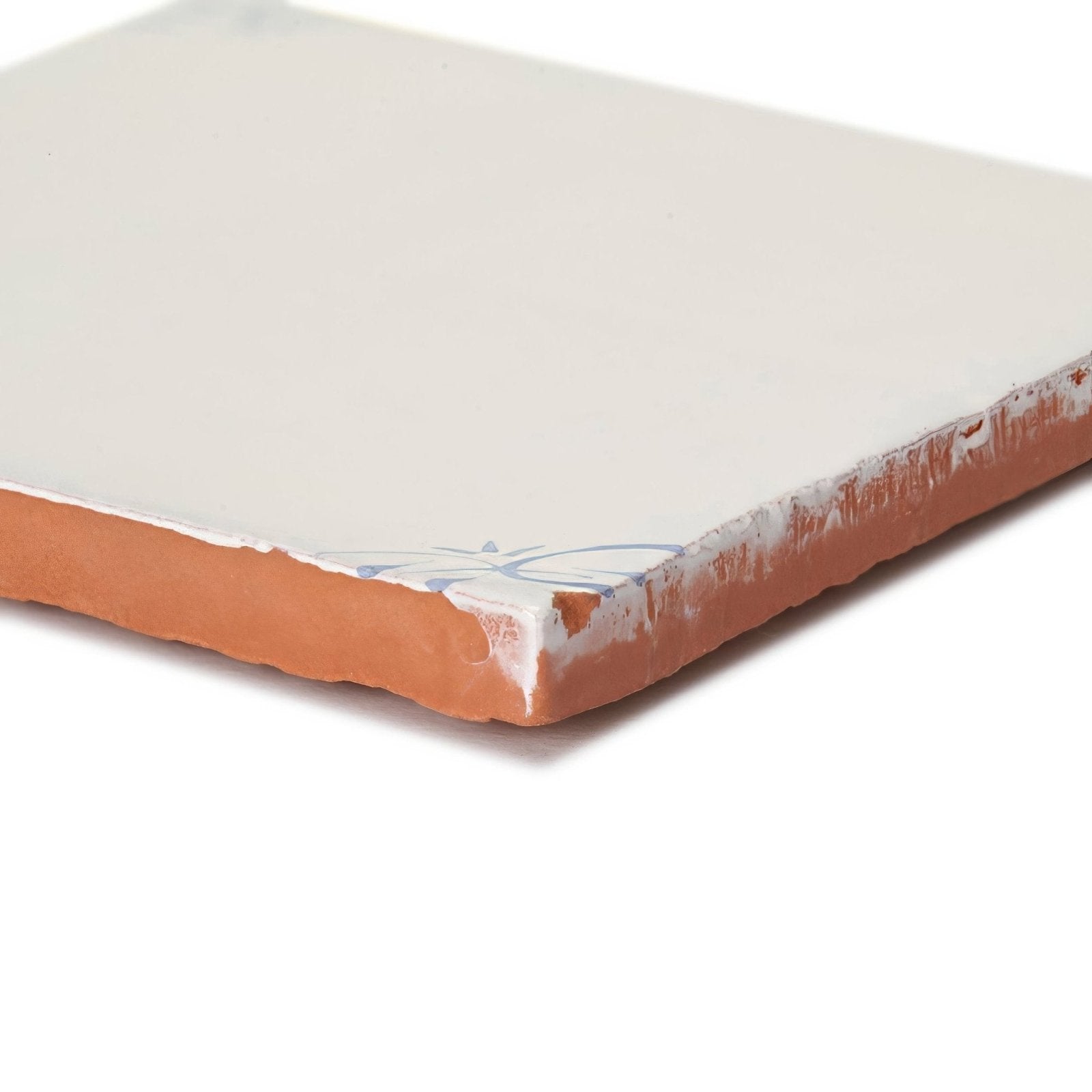 English delft blue gloss corner tile featuring cream ceramic with terracotta edge and subtle blue floral design