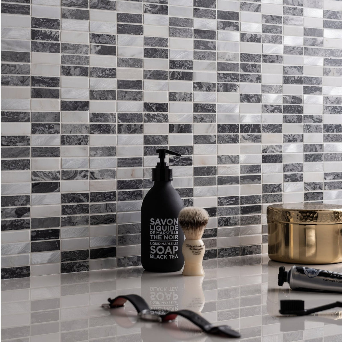 Eris Running Brick Mosaic grey and white marble brick mosaic with a black liquid soap bottle
