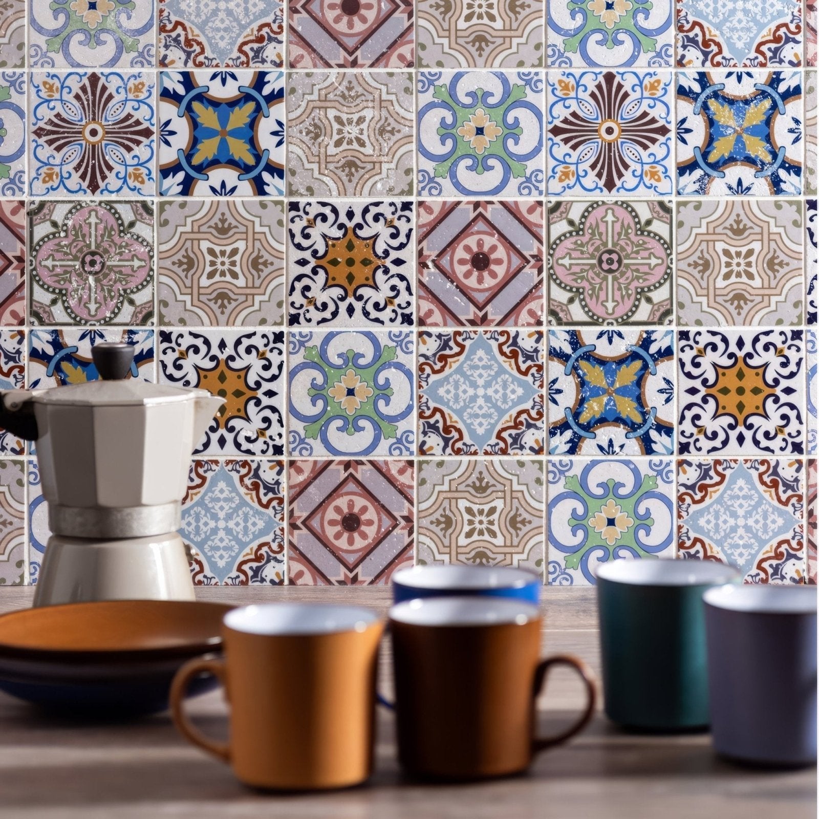 A white ceramic moka pot with a black knob and metallic base from the fable patterned mosaic collection
