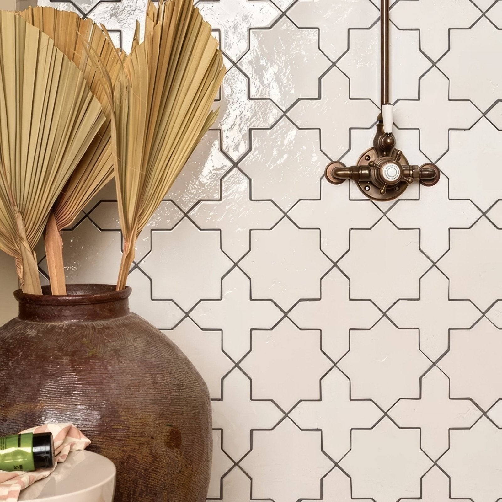 A rustic brown porcelain vase holding dried golden palm fronds featured in fez porcelain cross white collection