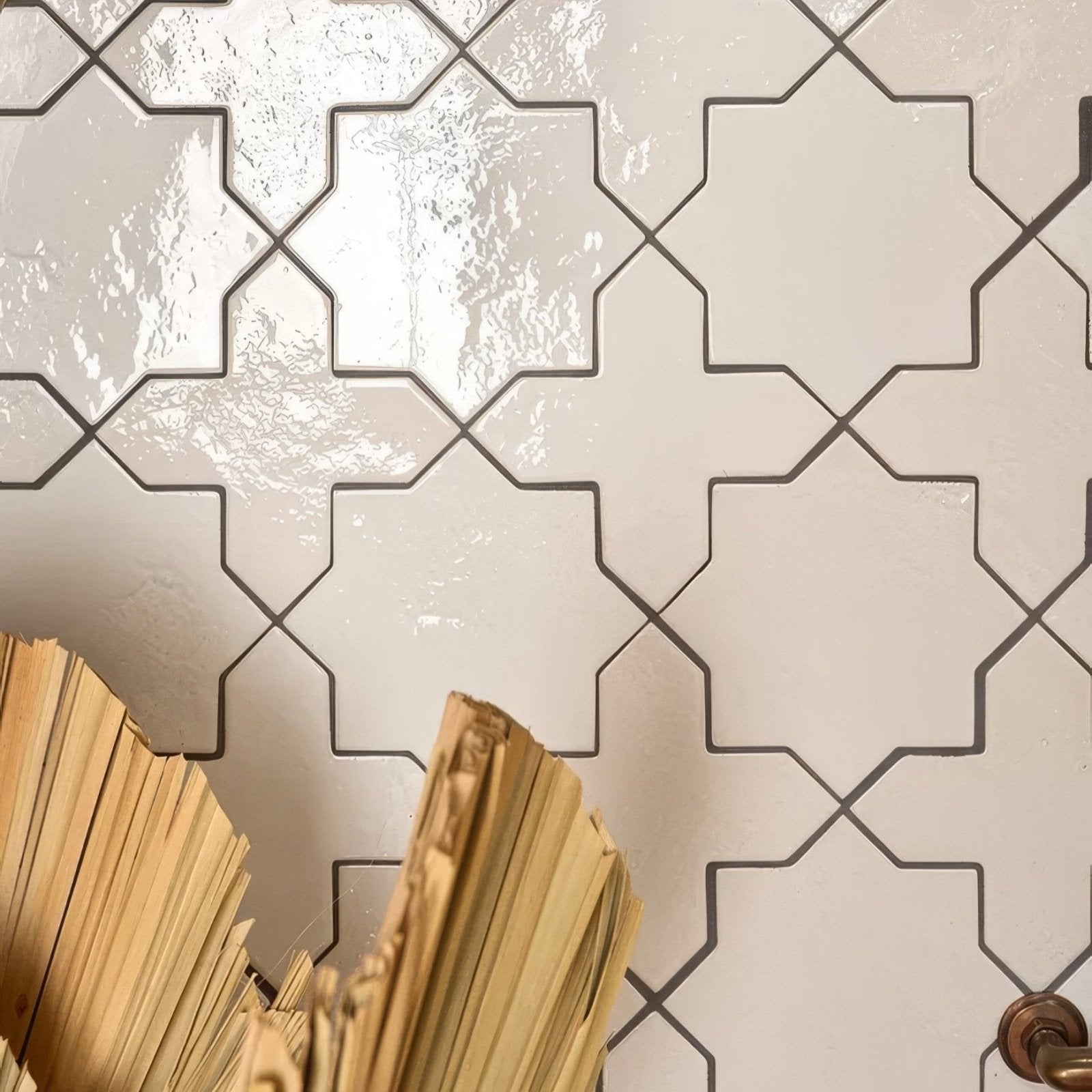 A stack of aged beige paper documents leaning against fez porcelain star white glossy tiles with dark gray geometric patterns