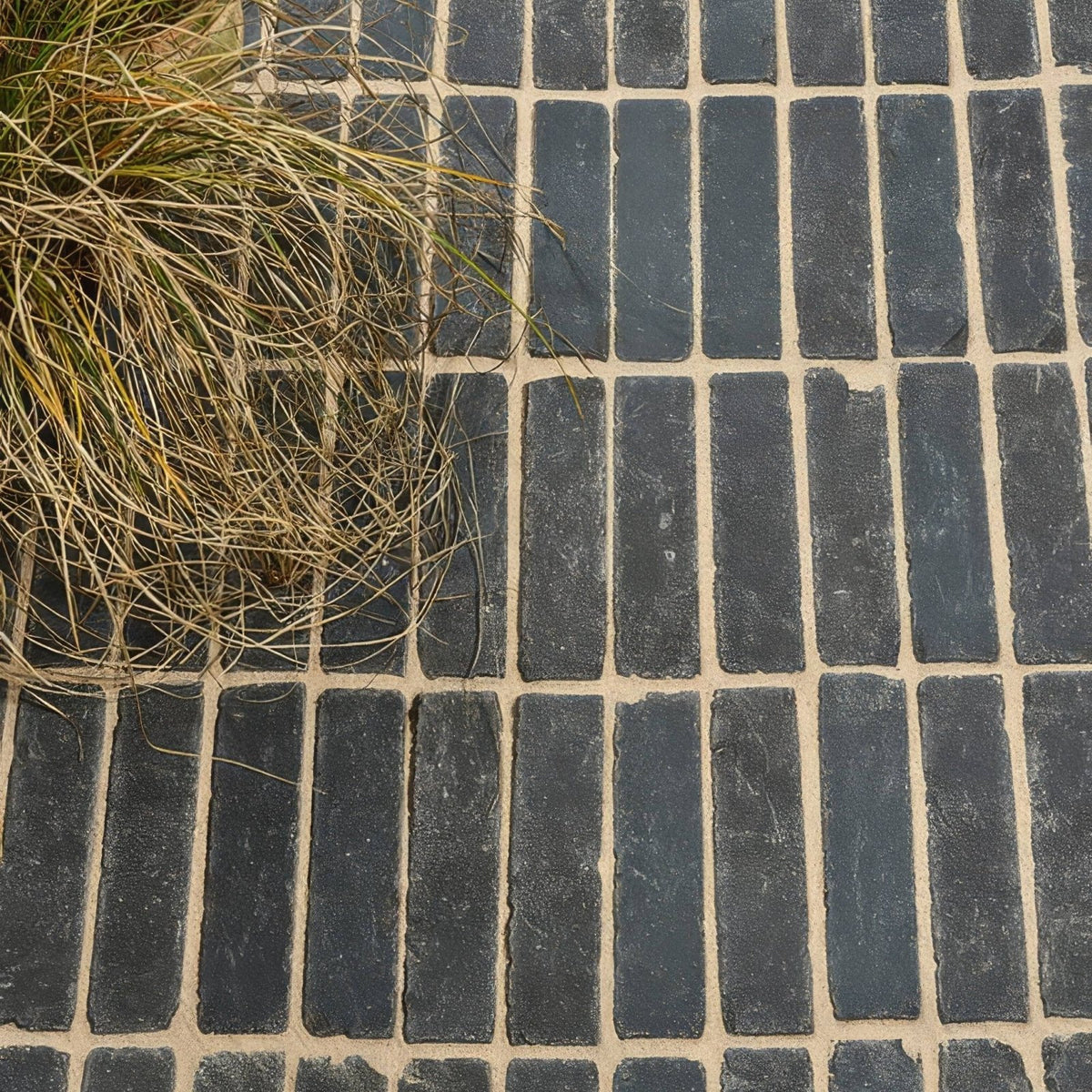 Flanders charcoal tumbled clay pavers in dark gray rectangular bricks with light beige mortar in running bond pattern