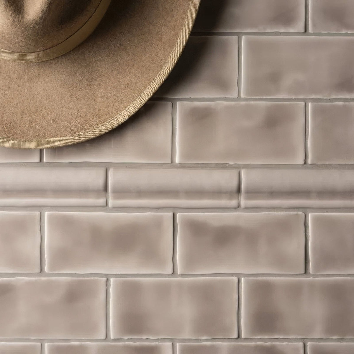 Beige rectangular ceramic flint half tile wall tiles with subtle matte finish arranged in a classic brick pattern