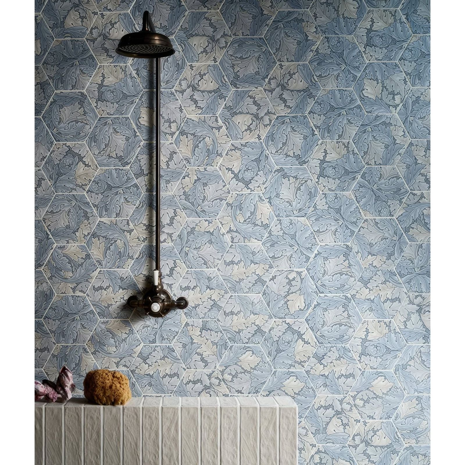 A vintage-style black metal showerhead with long vertical pipe and ornate cross-handle mounted on folly porcelain lake matt tiles
