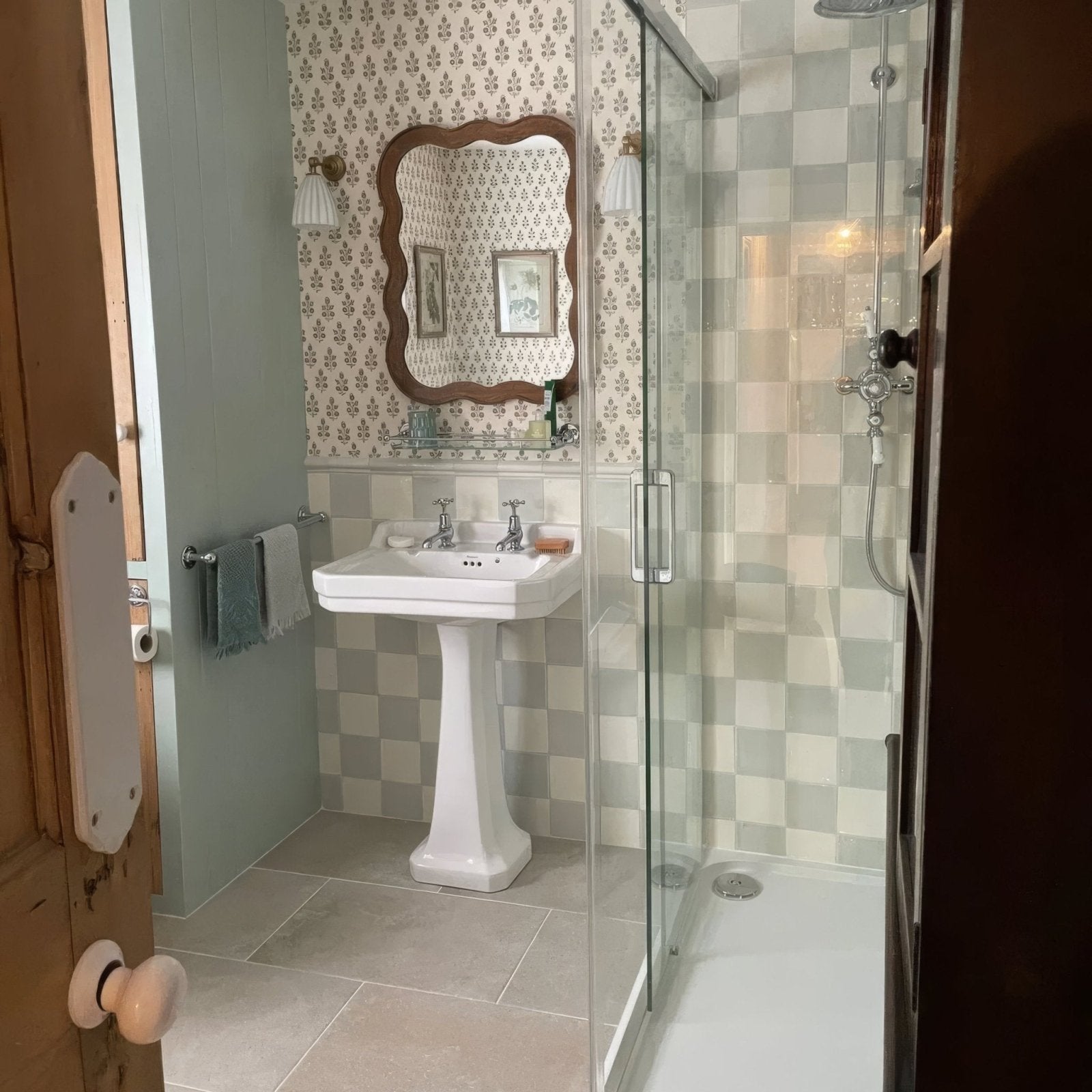 White pedestal sink with chrome faucets installed against forecast arran square glazed tile wall