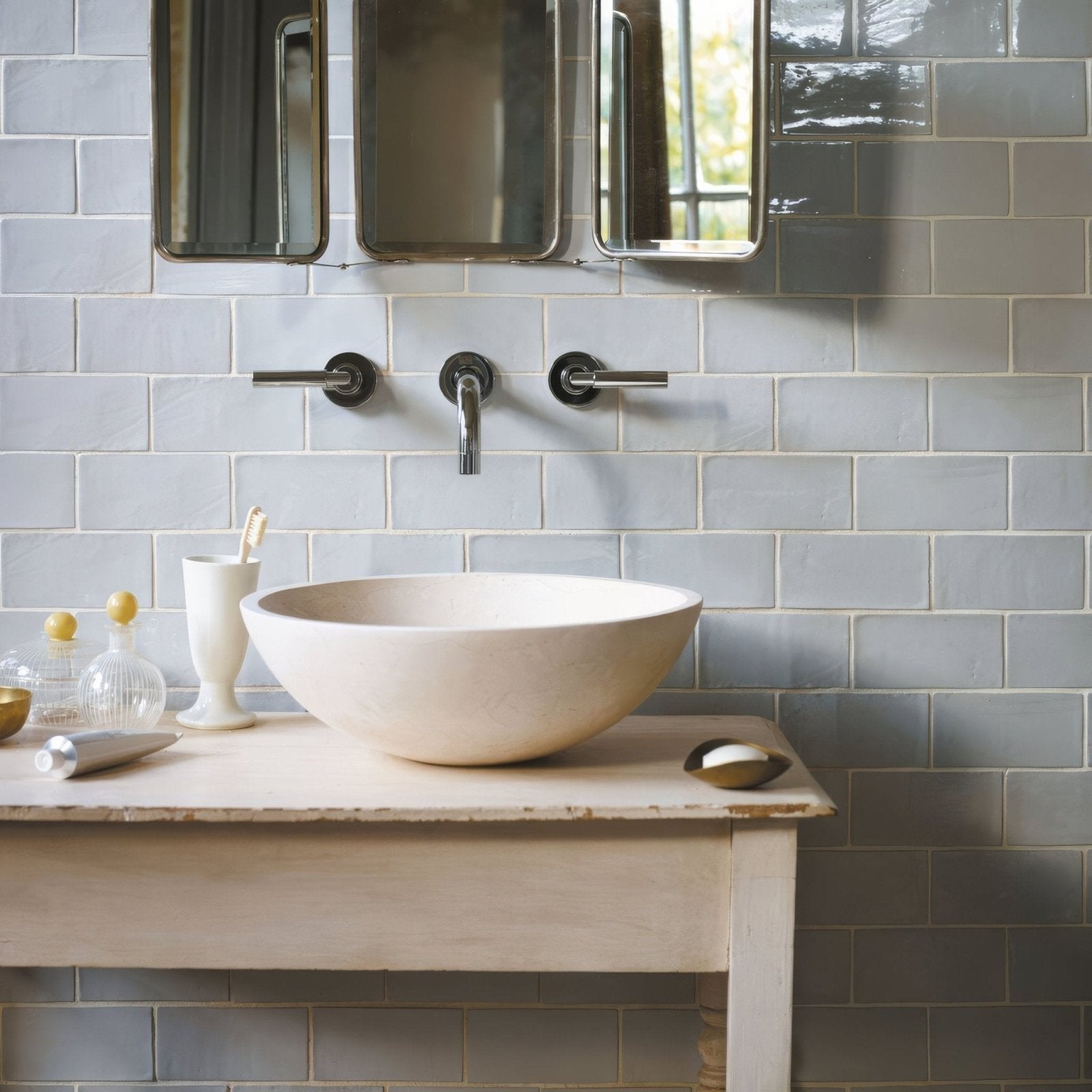 Cream-colored ceramic vessel sink with smooth rounded bowl shape paired with forecast cromarty rectangle glazed tile
