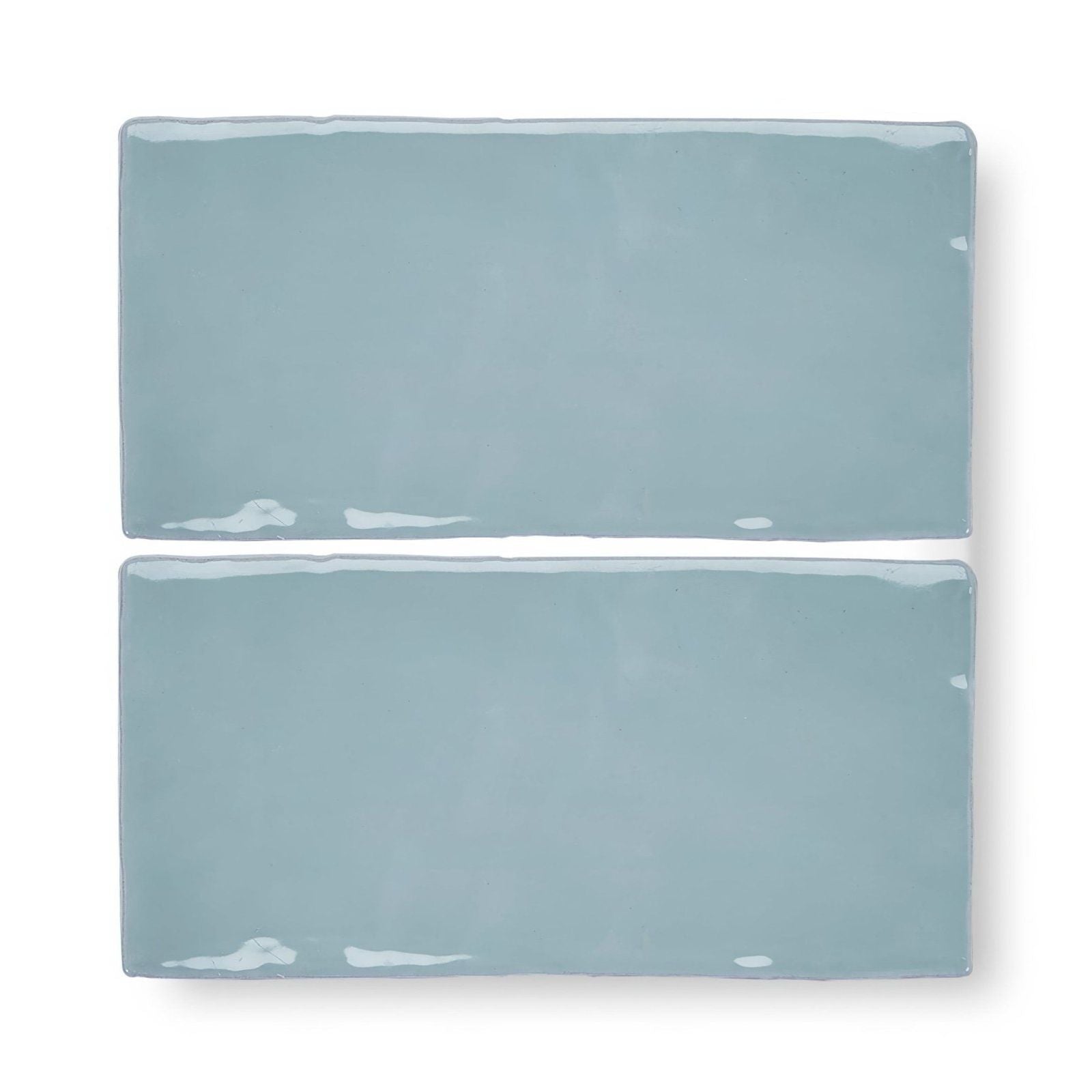 Two forecast forth rectangle glazed tiles with matte light blue ceramic finish and white speckles on edges