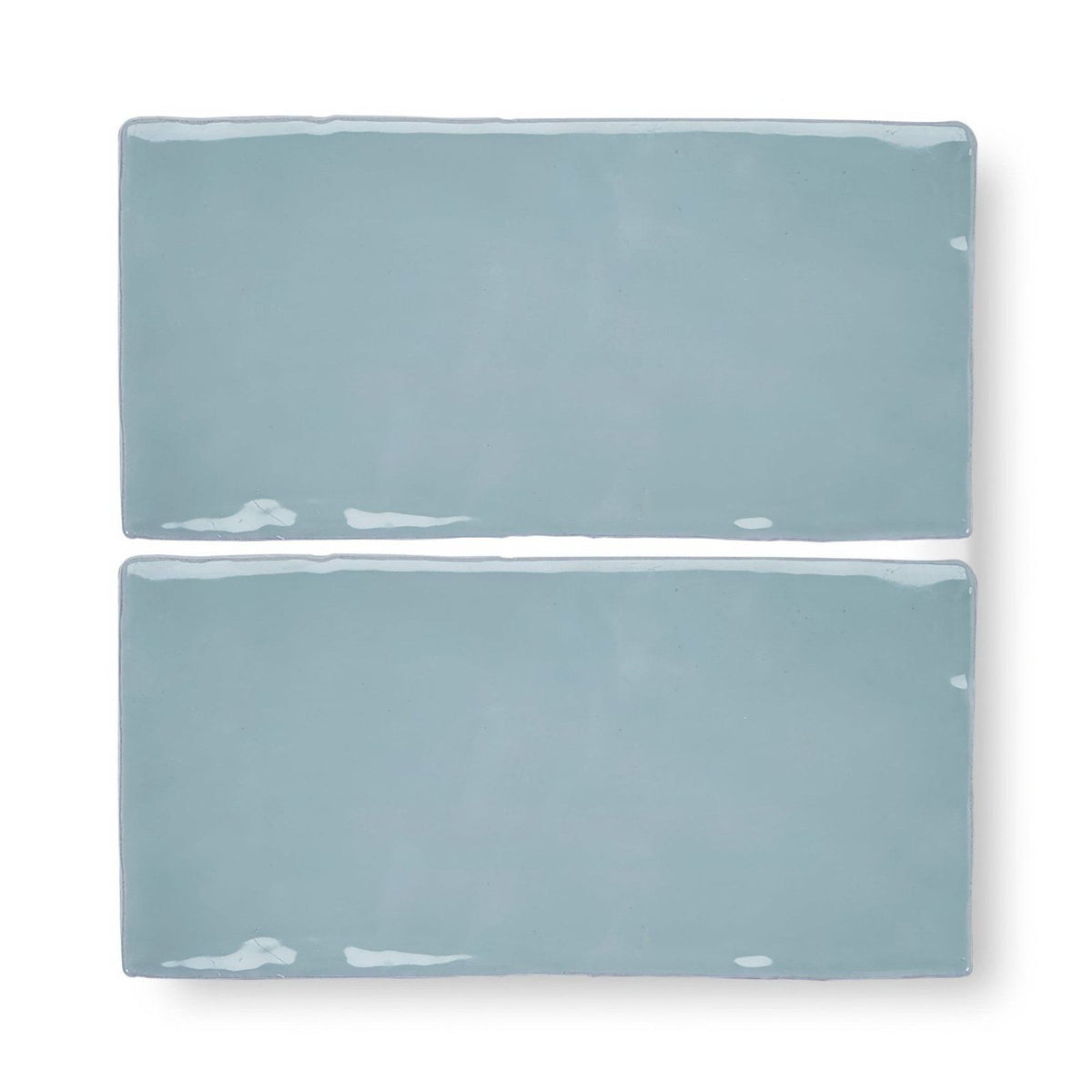 Two forecast forth rectangle glazed tiles with matte light blue ceramic finish and white speckles on edges