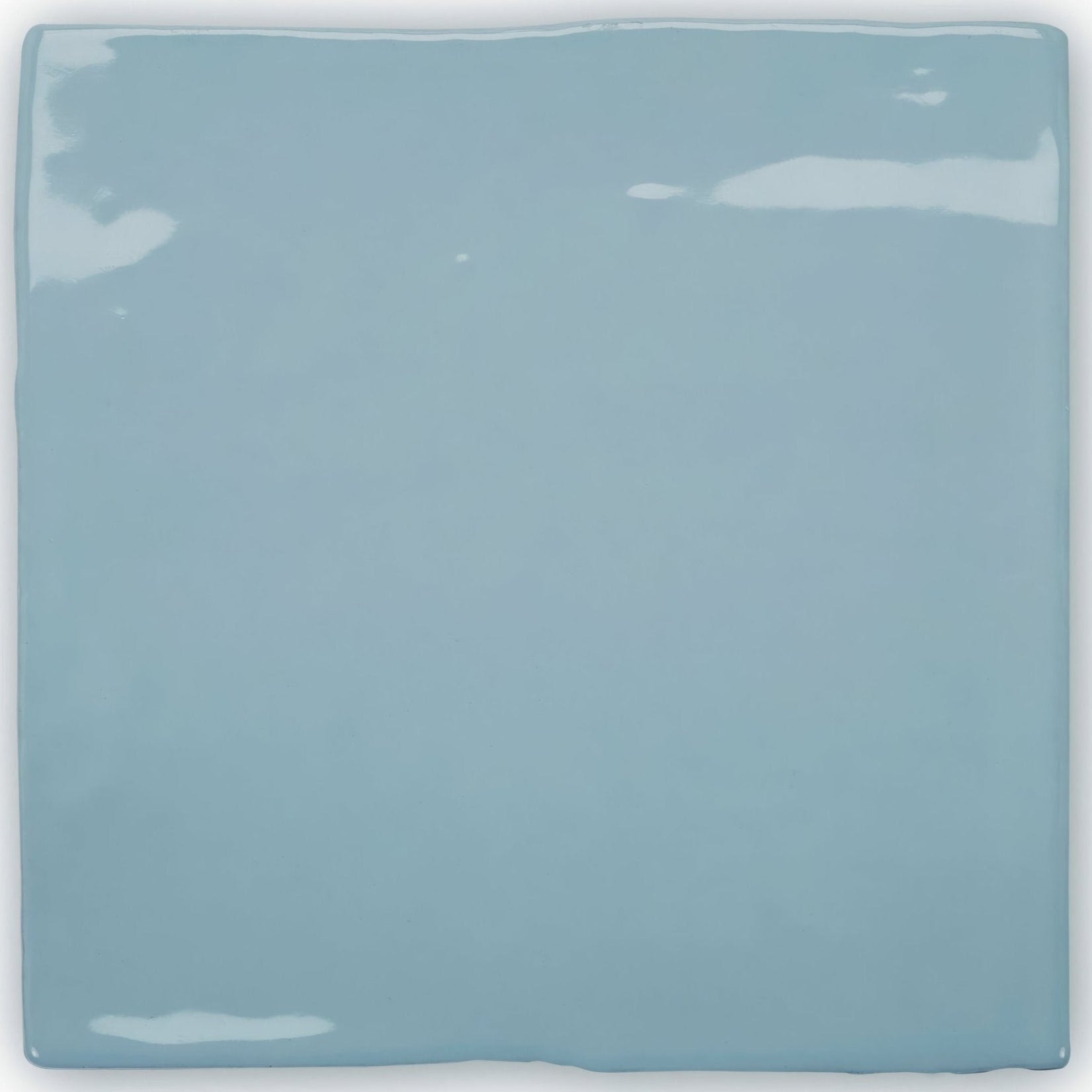 A square glossy light blue ceramic tile with slightly uneven edges from forecast forth square glazed tile collection