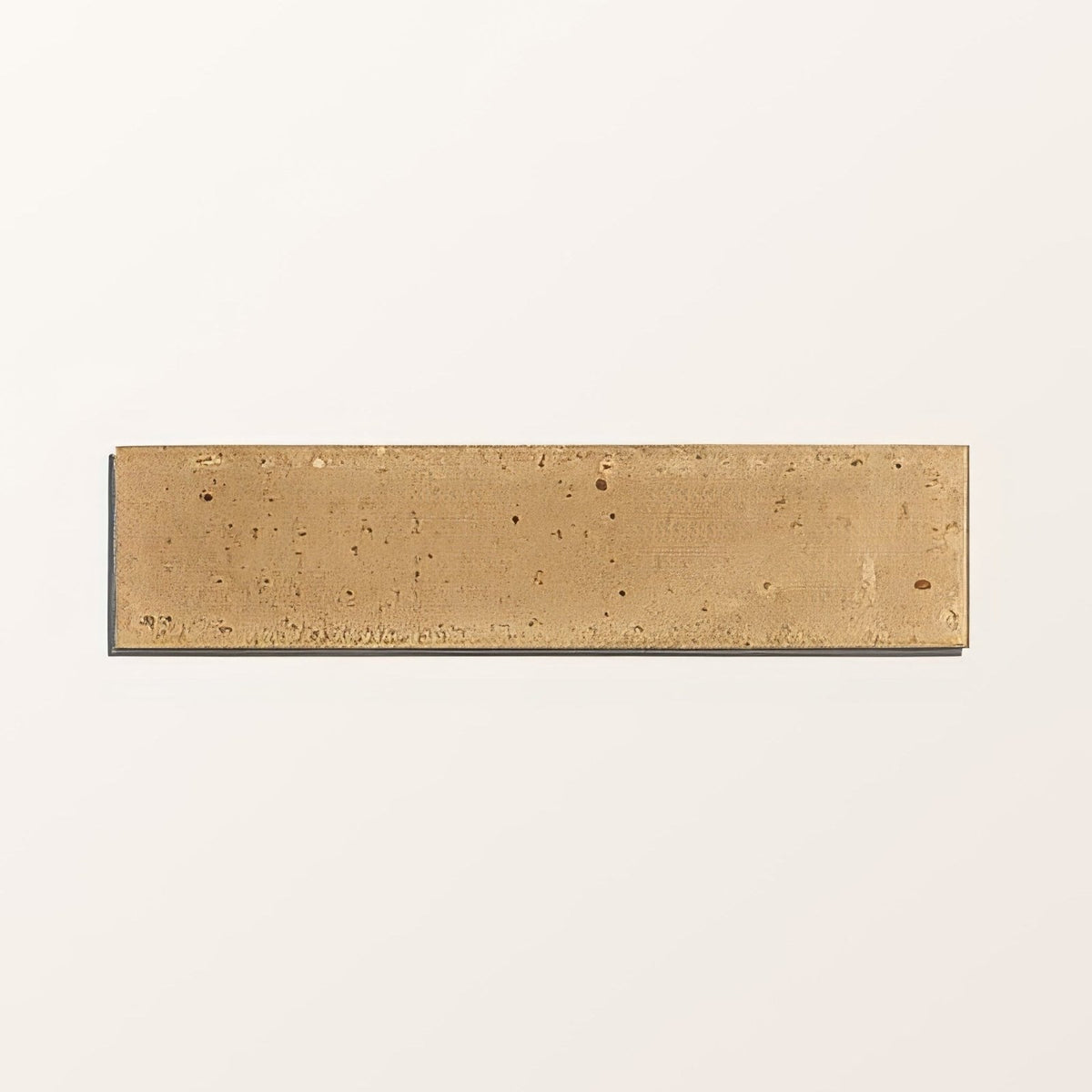 A rectangular matte-finished brass tile with subtle speckled texture from foundry novo porcelain beige collection
