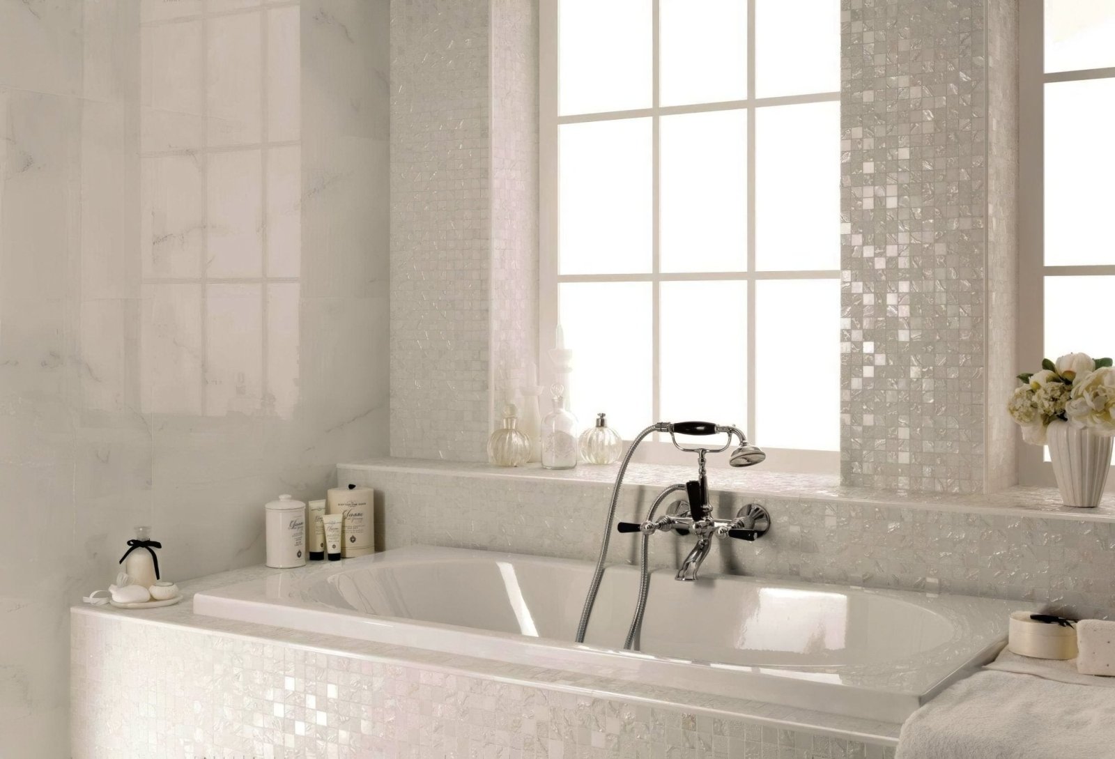 Four Seasons Snow Mosaic white and grey mosaic with a white marble bathtub and chrome tap