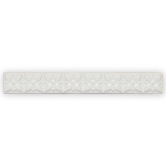 White ceramic tile giralda cascara cream trim with a repeating embossed floral pattern for wall decoration