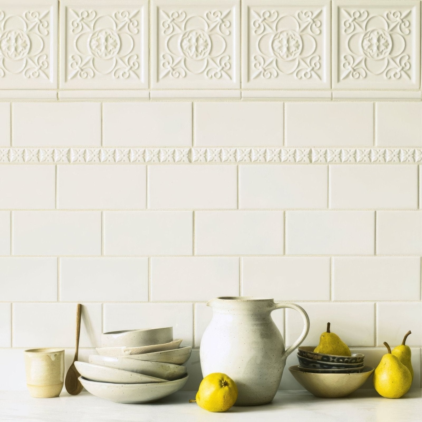 Cream-colored ceramic pitcher with rustic handcrafted finish and curved handle featured with giralda hielo white tile