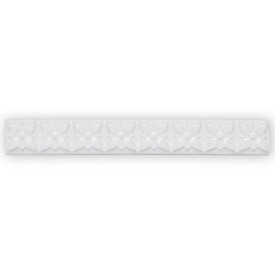 White ceramic tile giralda hielo white trim with a repeating embossed floral pattern for decorative wall use