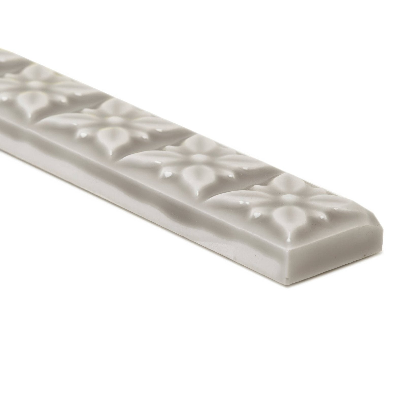 Gray ceramic tile giralda niebla grey trim with raised floral patterns along its length for decorative edging