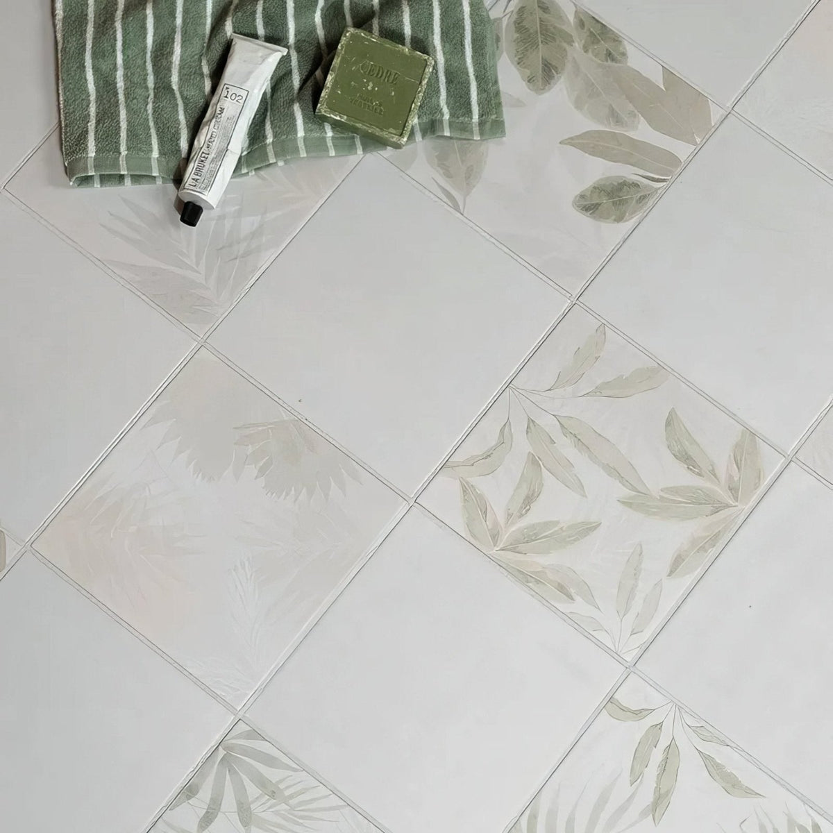 White rectangular glass house porcelain tiles with subtle gray leaf patterns arranged in a diagonal layout