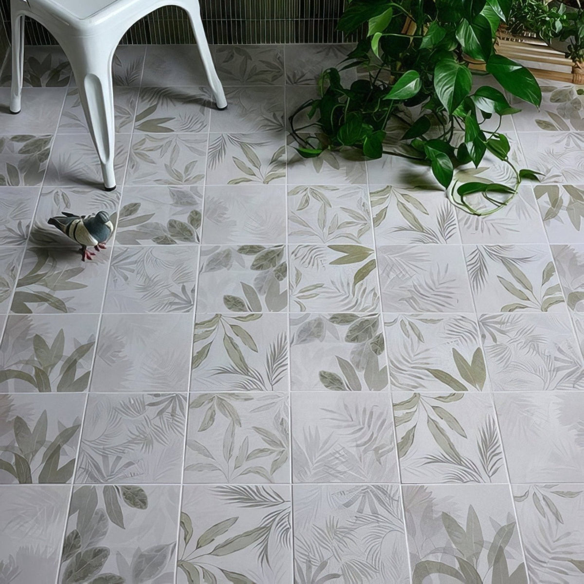 White glass house porcelain floor tiles with subtle gray and green leaf pattern on a white background