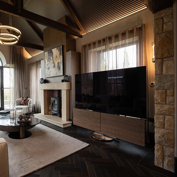 Black flat-screen television mounted on goodrich charred oak wooden slat console showcasing modern living room setup