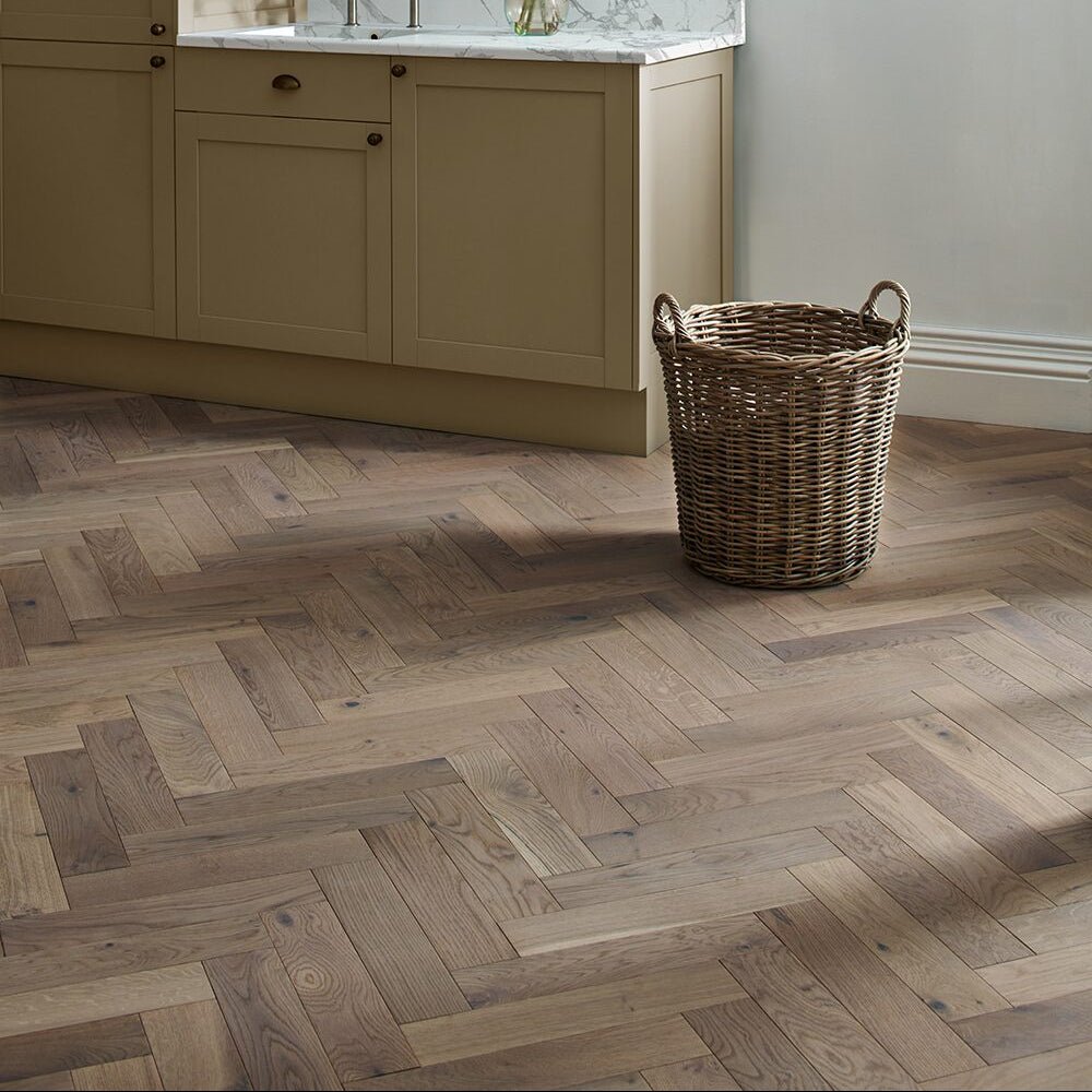 Natural-toned white oiled oak wooden floor planks arranged in a herringbone pattern for elegant flooring