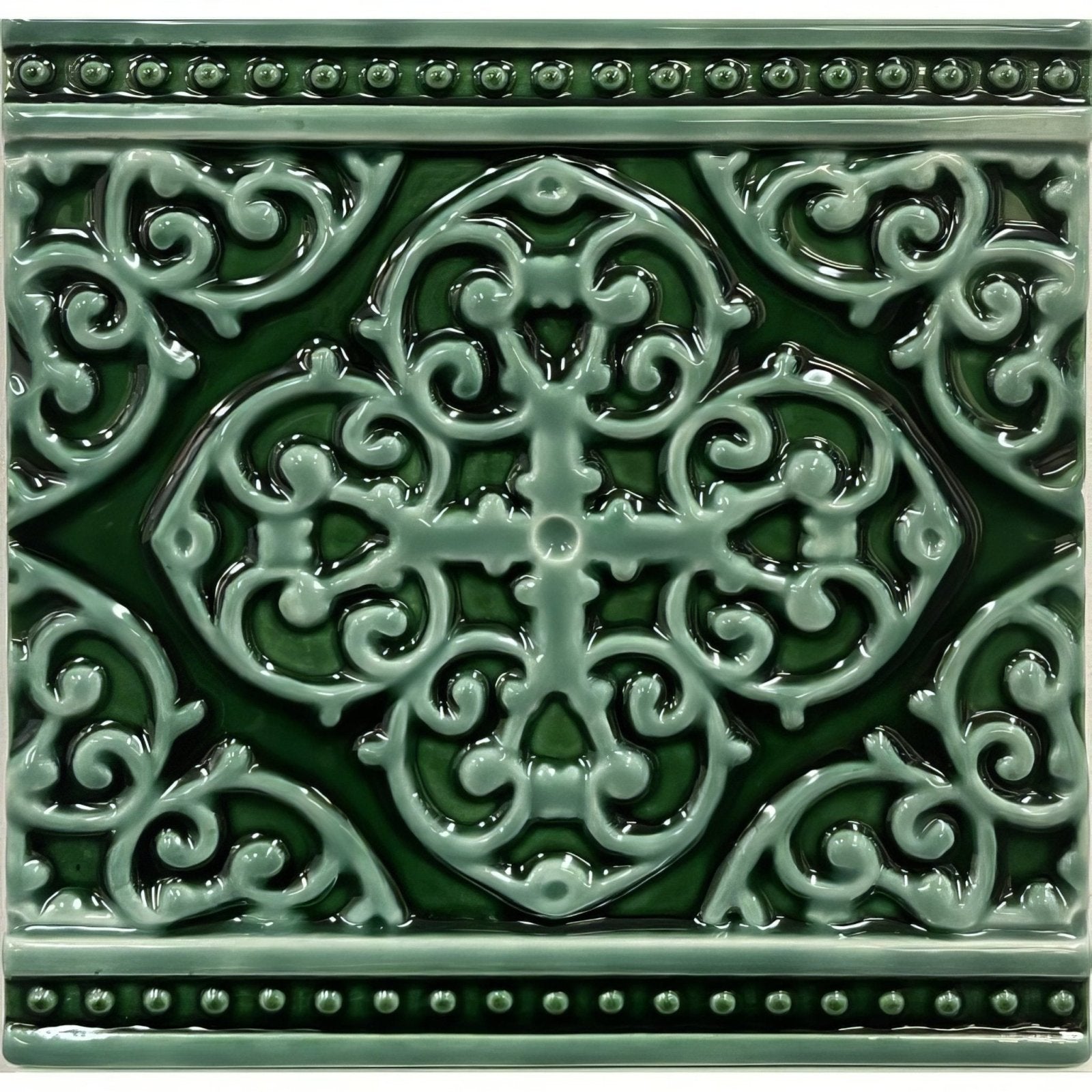A square glossy green ceramic tile with an intricate raised quatrefoil design and beaded borders grosvenor jade breeze on victorian green