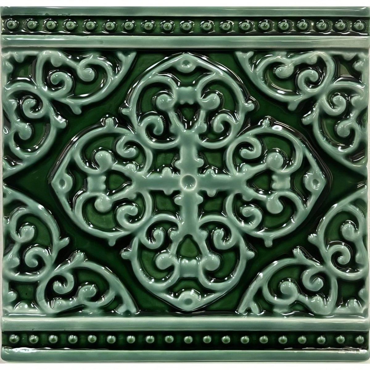 A square glossy green ceramic tile with an intricate raised quatrefoil design and beaded borders grosvenor jade breeze on victorian green
