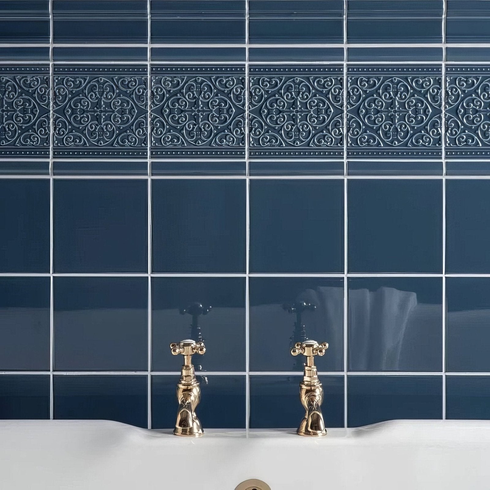 Deep blue glossy ceramic Grosvenor On Ascot blue tiles with ornate white border and gold-finished faucets