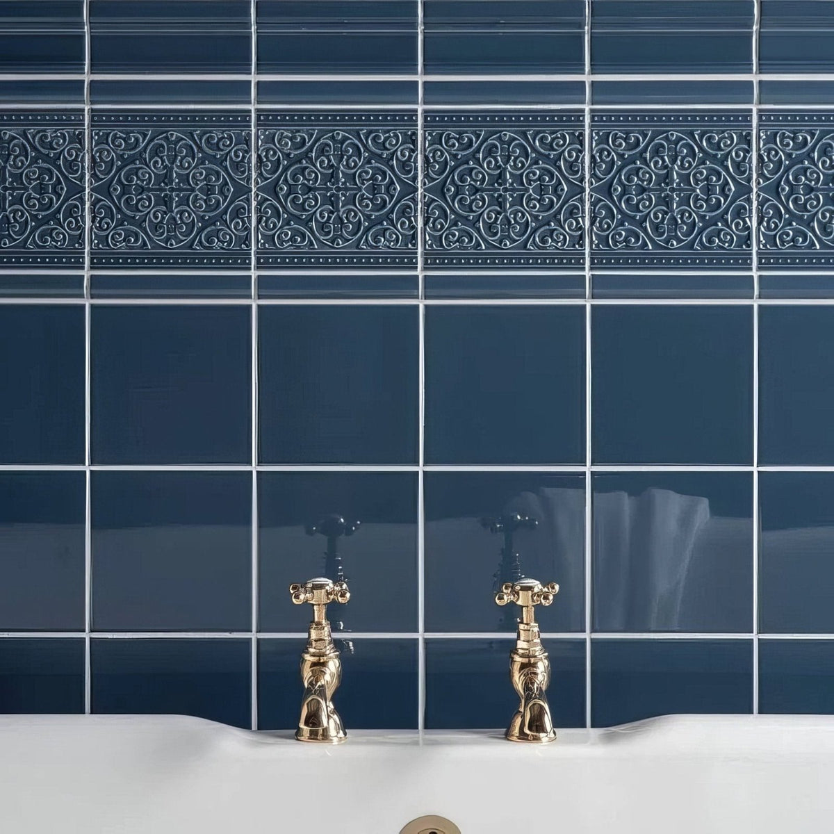 Deep blue glossy ceramic Grosvenor On Ascot blue tiles with ornate white border and gold-finished faucets