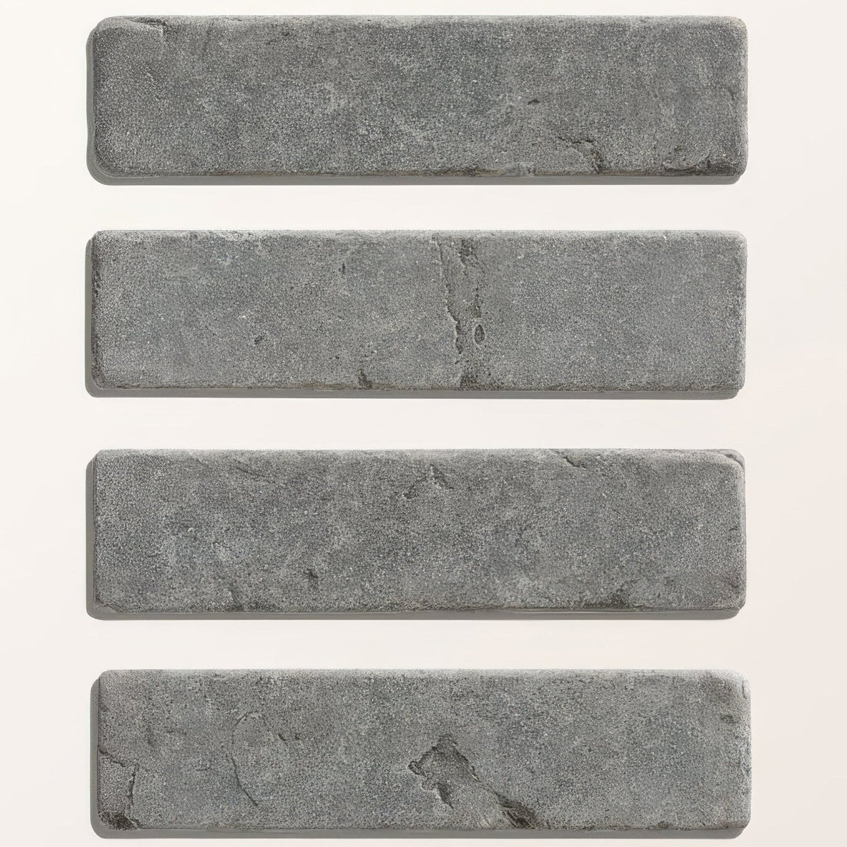 Four rectangular gray hazlebury limestone tumbled and etched klinkers with textured natural surface and tone variations