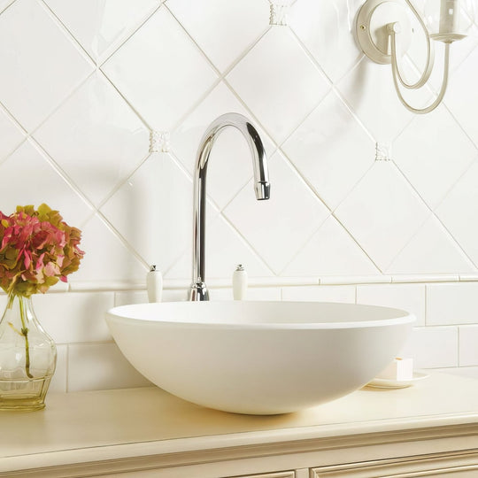 White ceramic vessel sink with sleek chrome faucet featured in helmingham field tile bathroom setup